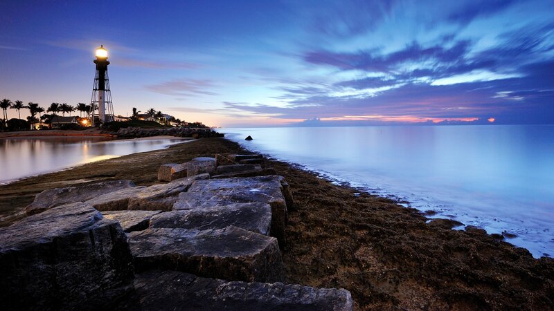 Lighthouse at Dusk — Blue, Serene, Sunset, Photograph, Ocean, Rocks
