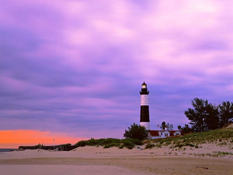 Lighthouse at dusk on a sandy beach