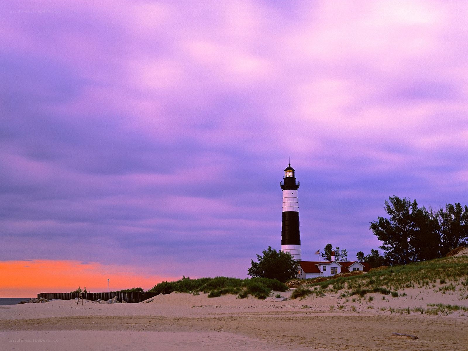 Lighthouse at dusk on a sandy beach