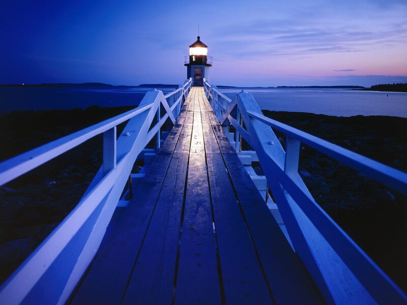 Lighthouse at dusk on a wooden pier