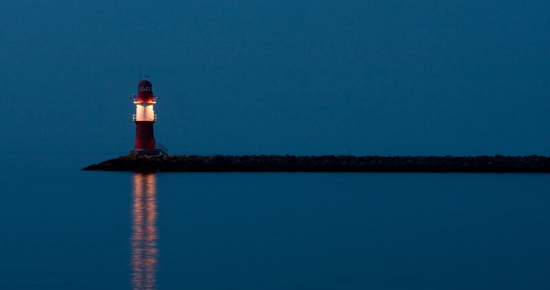 Lighthouse at dusk on calm water