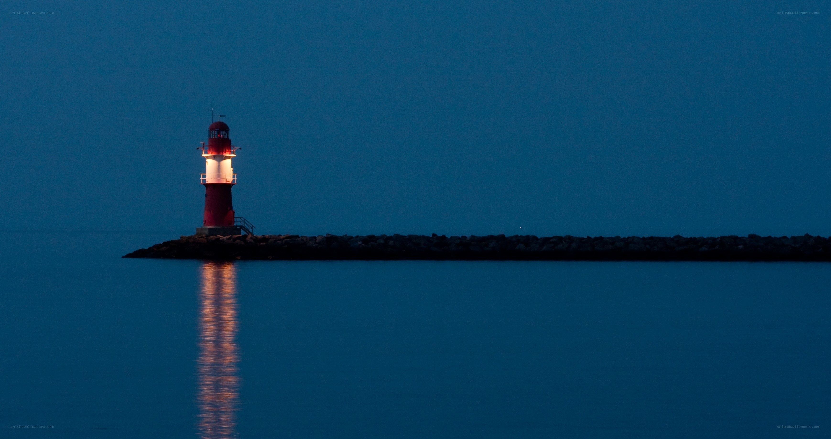 Lighthouse at dusk on calm water