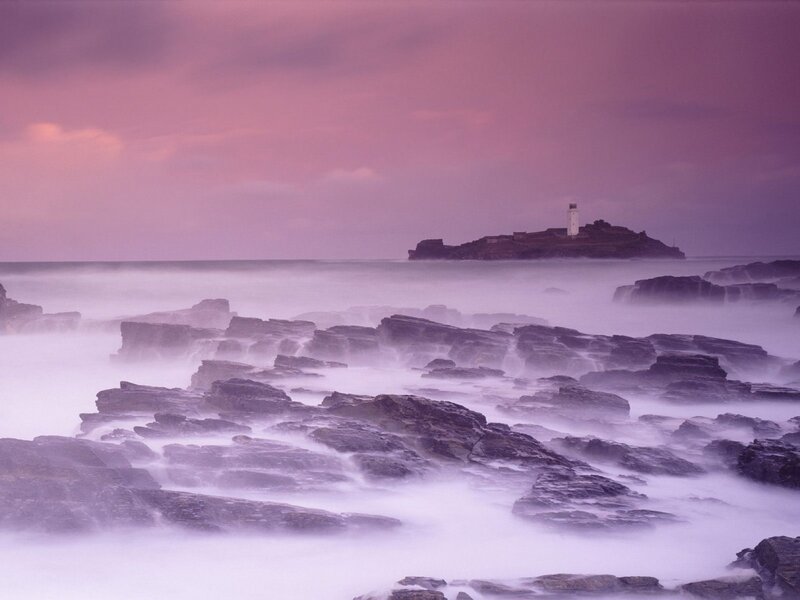 lighthouse at dusk on rocky coast