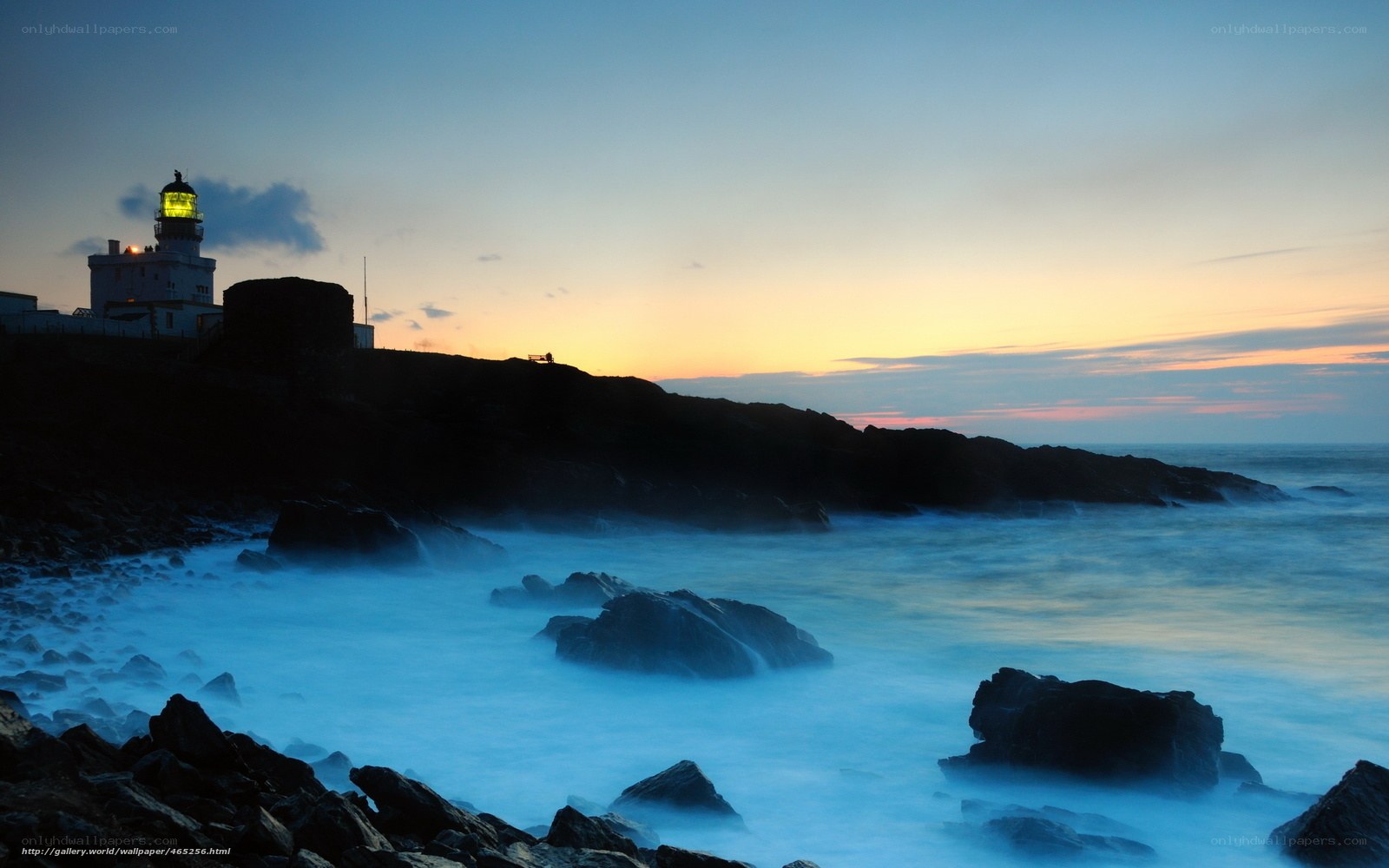 Lighthouse at dusk on rocky coast
