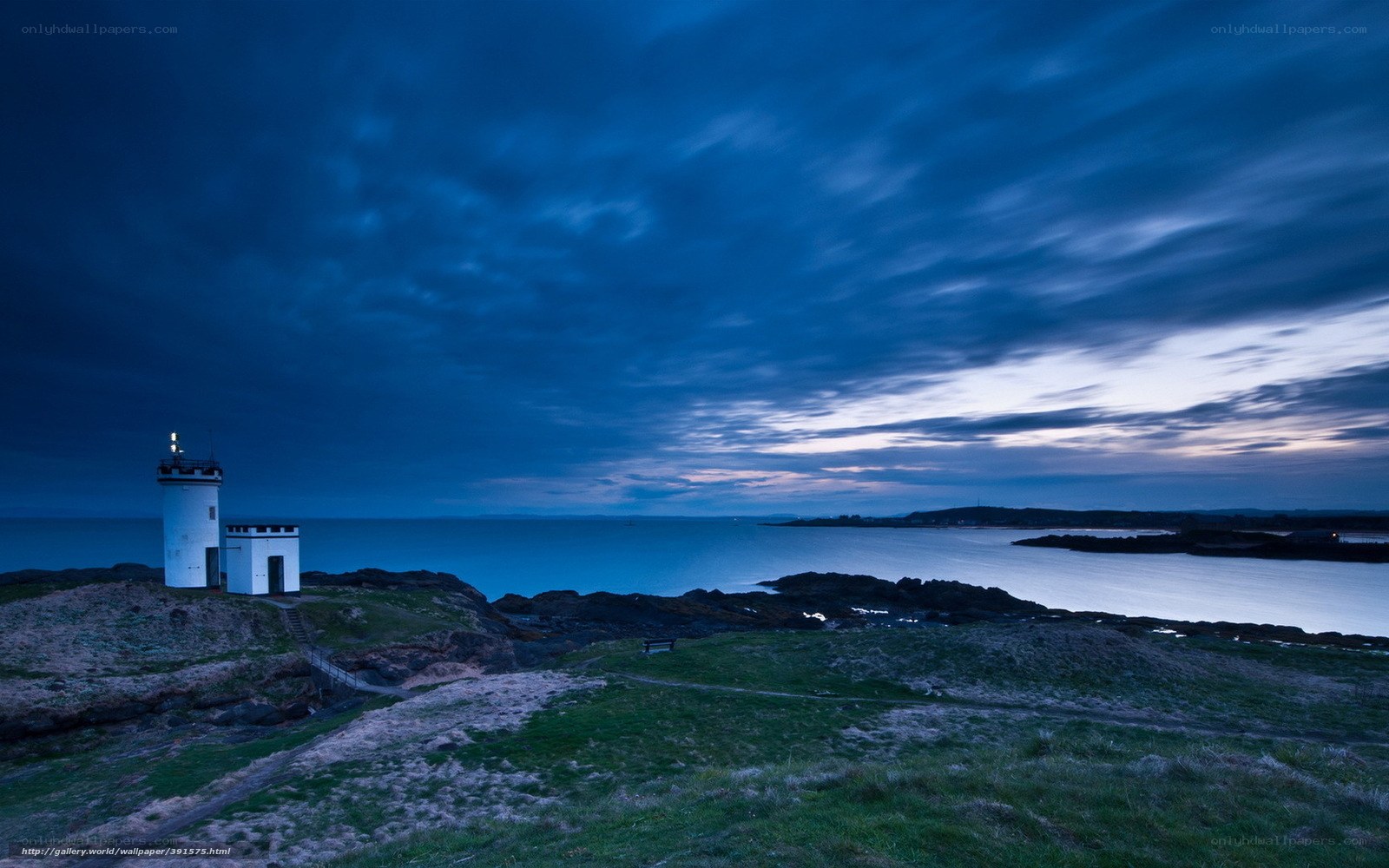 Lighthouse at dusk on rocky coast