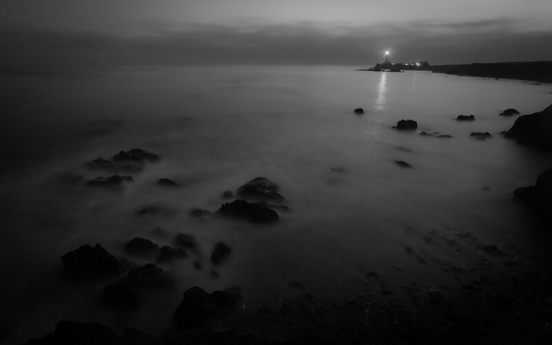 Lighthouse at dusk on rocky shore