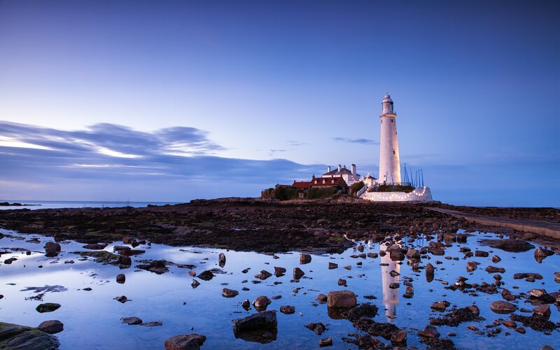 lighthouse at dusk on rocky shore