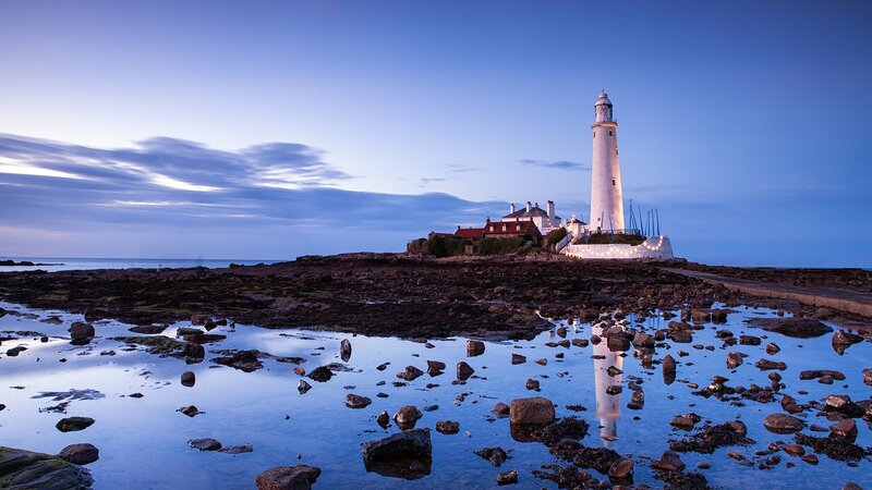 lighthouse at dusk on rocky shore