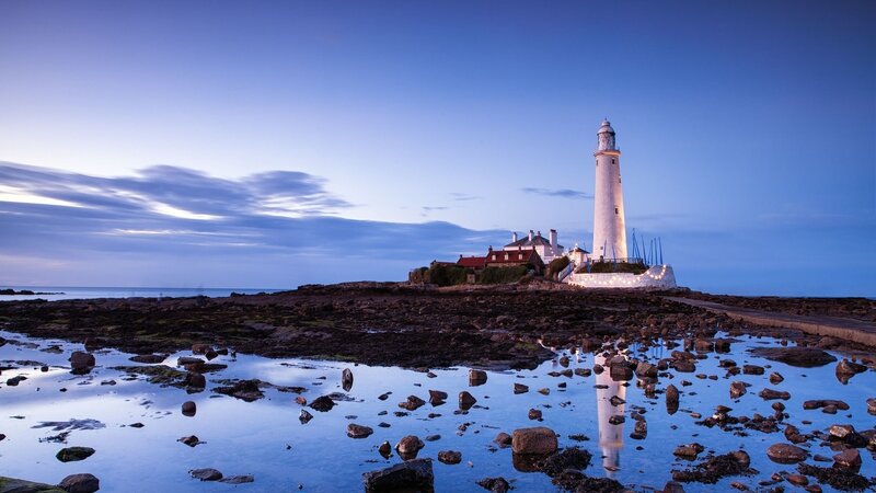 Lighthouse at dusk on rocky shore
