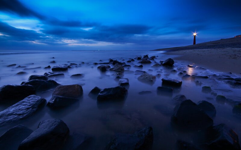 Lighthouse at dusk on rocky shore
