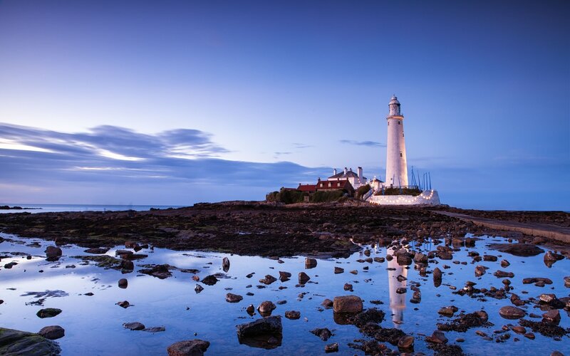 Lighthouse at dusk on rocky shore