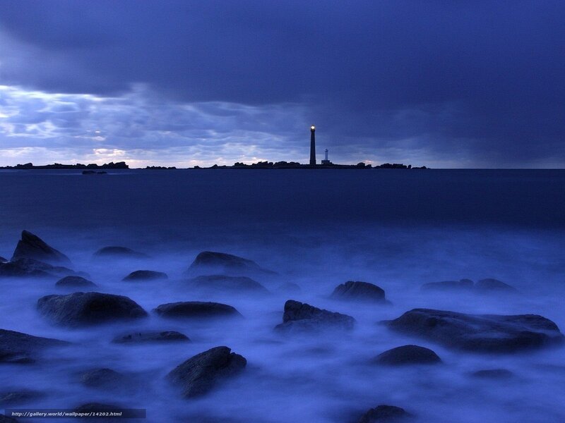 Lighthouse at dusk on rocky shore