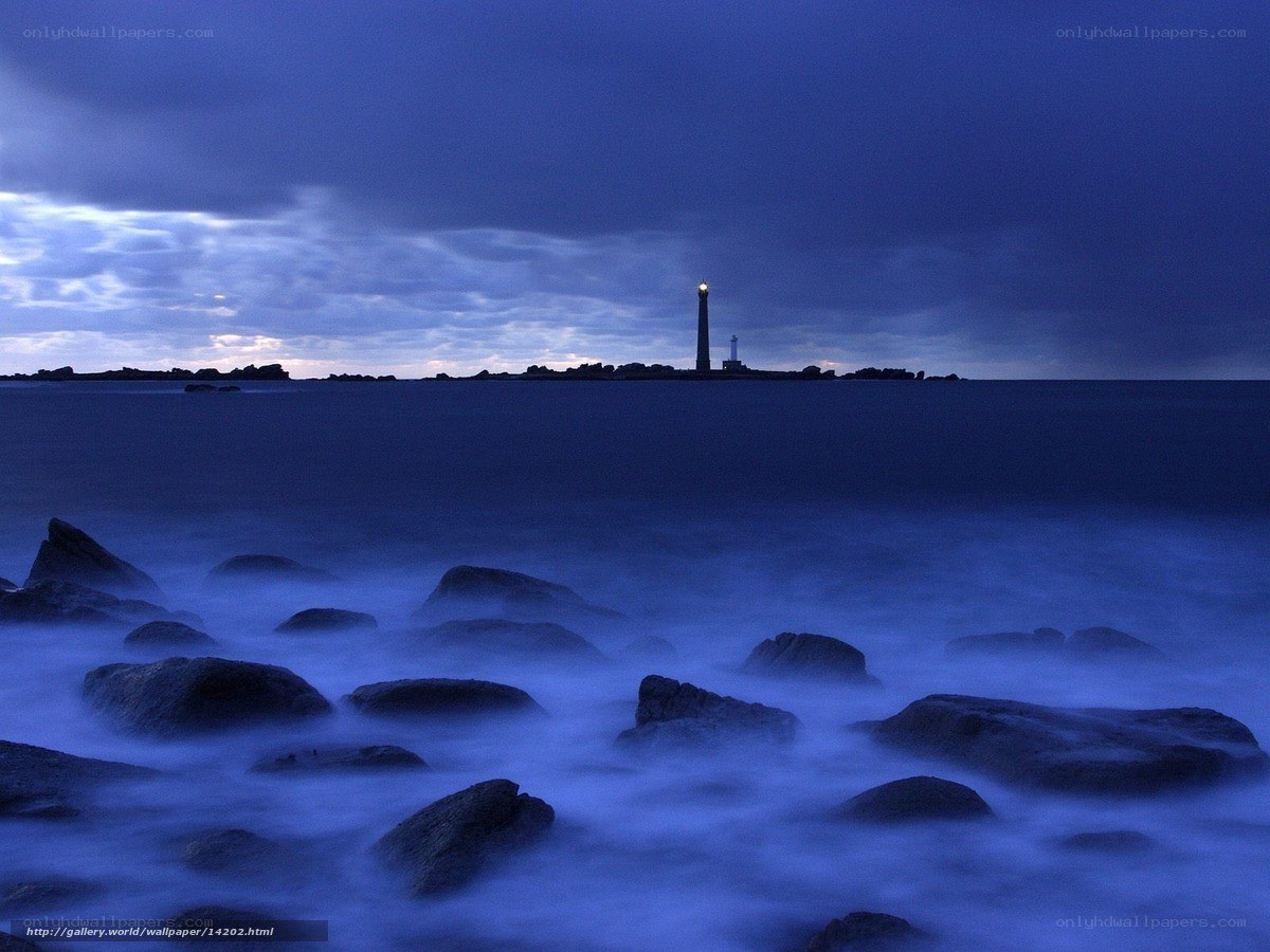 Lighthouse at dusk on rocky shore
