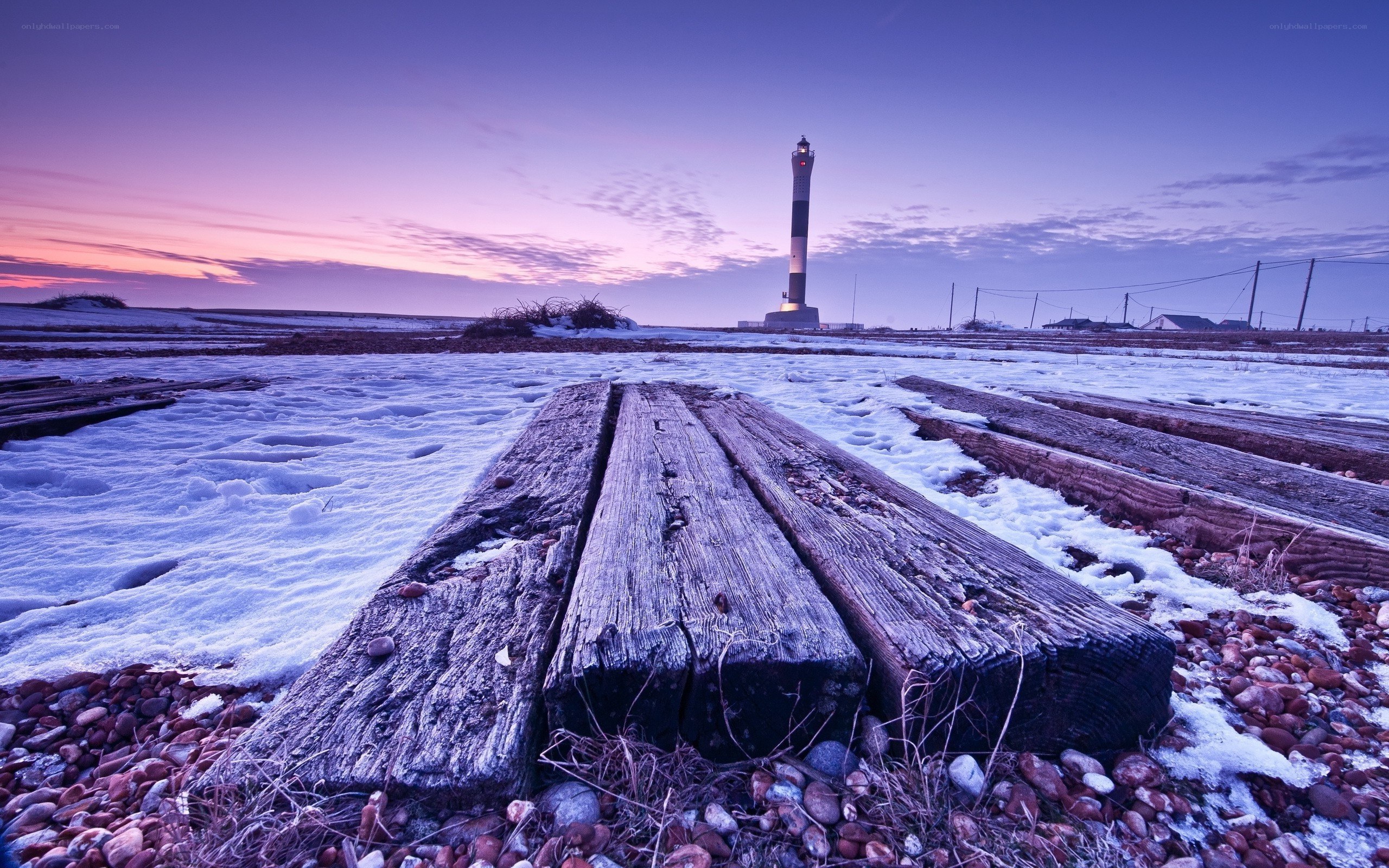 Lighthouse at dusk on snowy shore