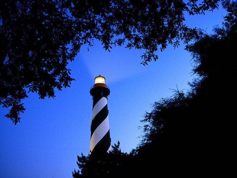 lighthouse at dusk through trees