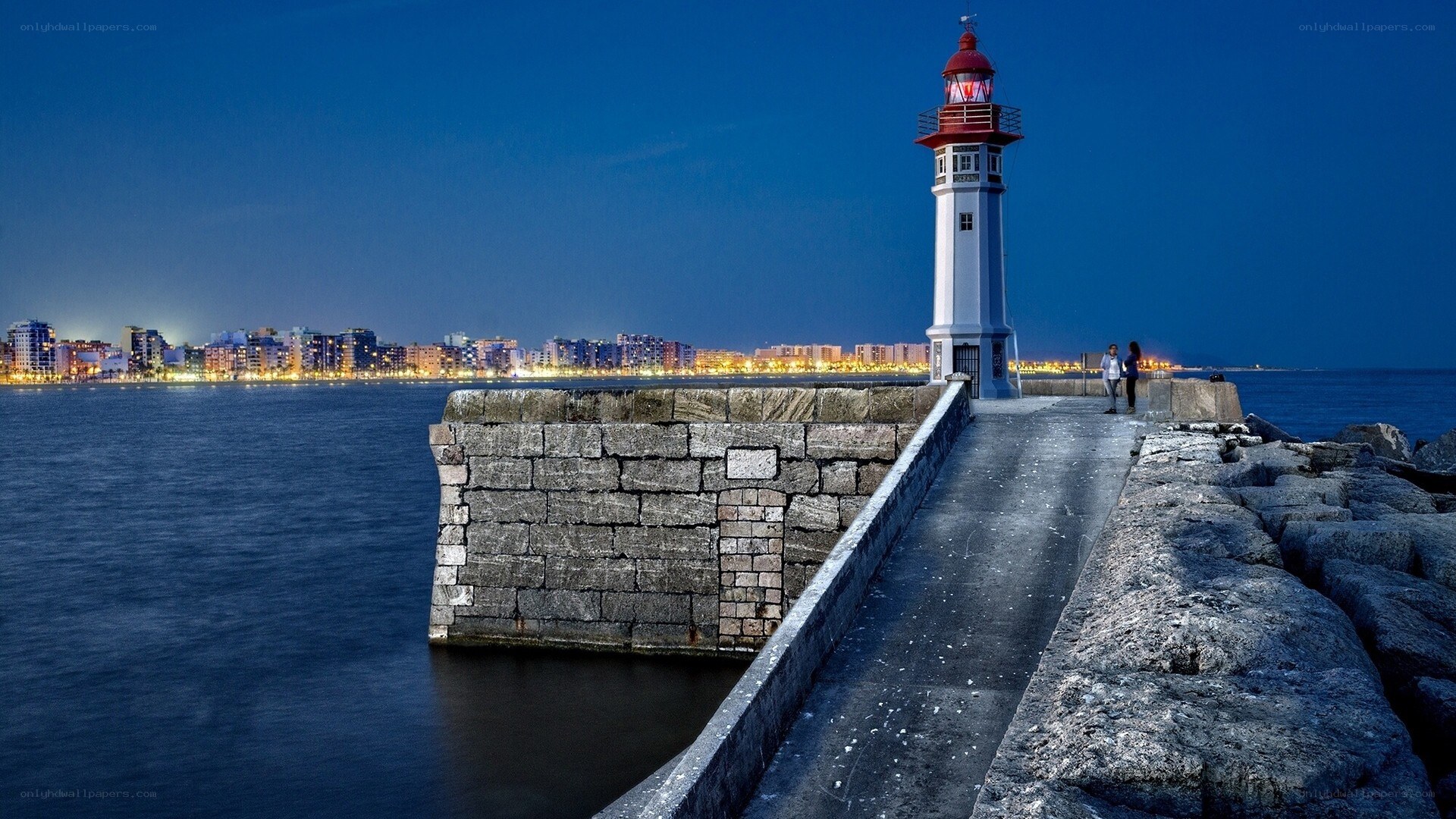 Lighthouse at dusk with city view