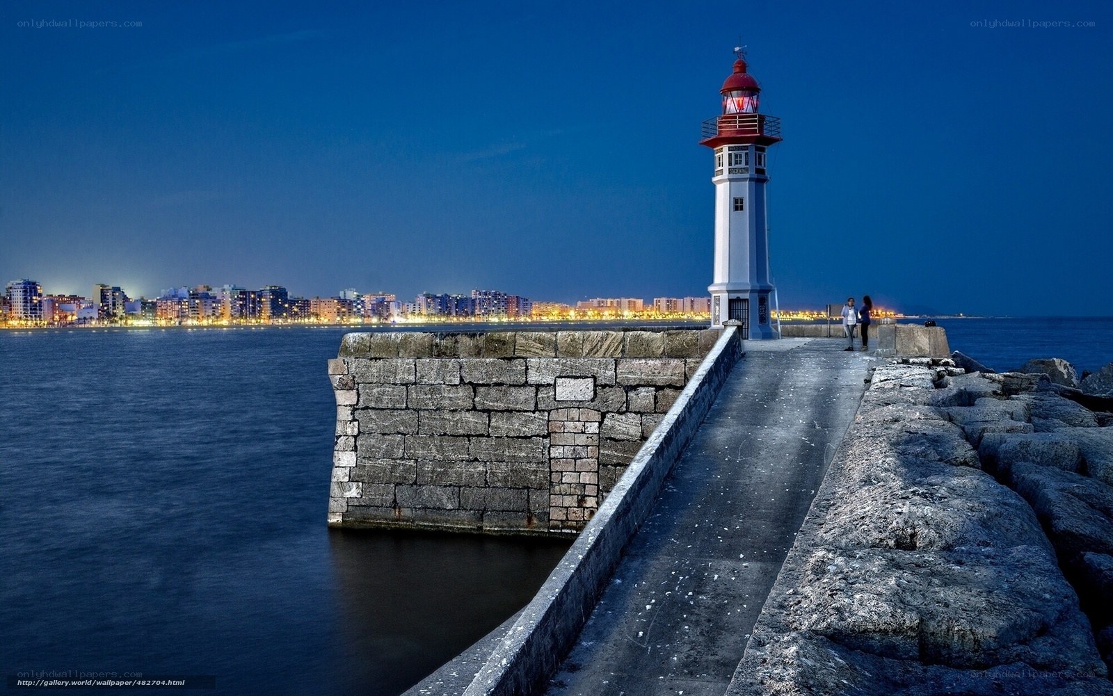 Lighthouse at dusk with city view