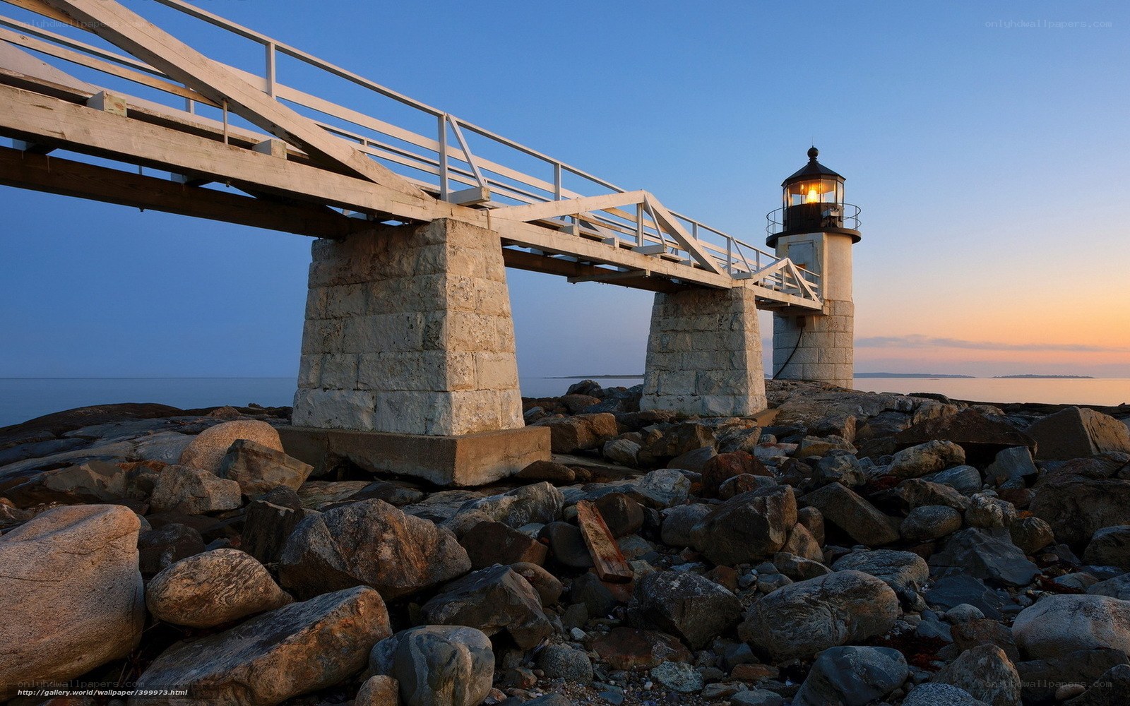 Lighthouse at dusk with stone pier
