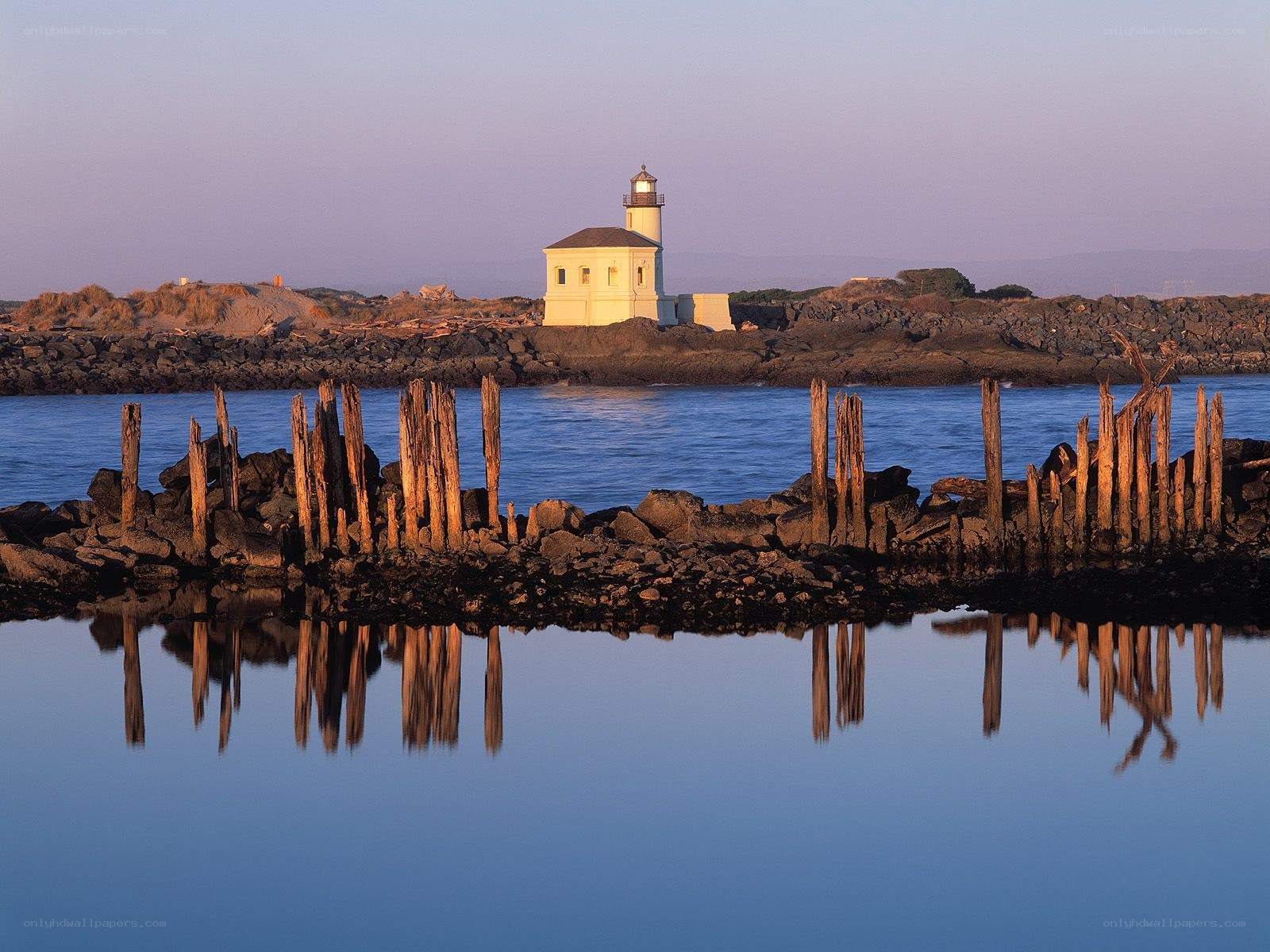 Lighthouse at dusk with wooden posts