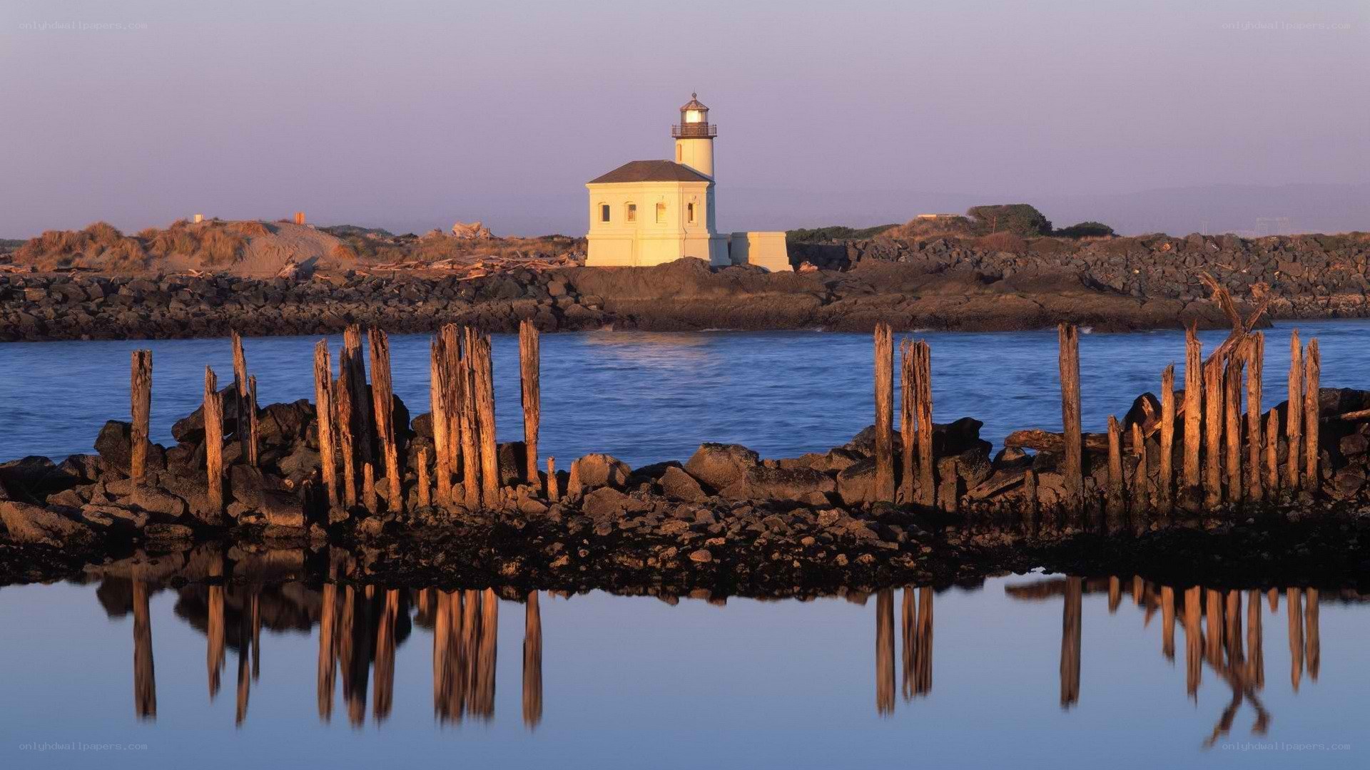 Lighthouse at dusk with wooden posts