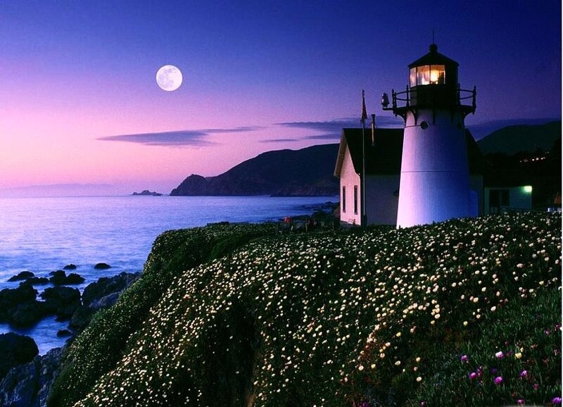 Lighthouse at moonrise by the sea