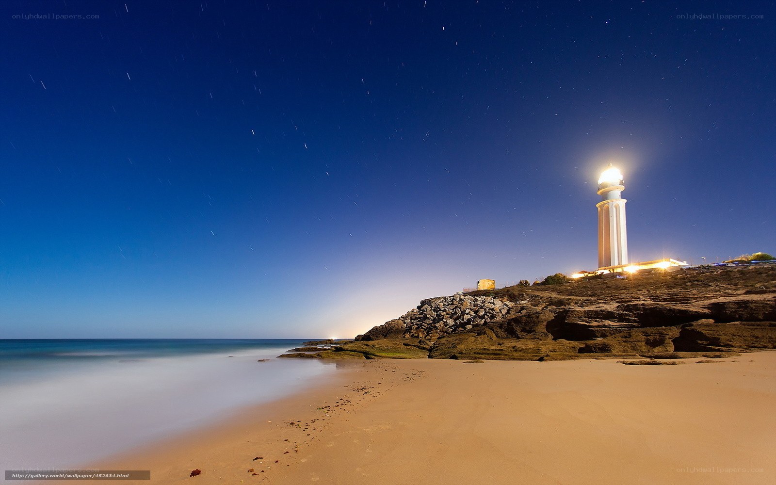 Lighthouse at night on a rocky coast