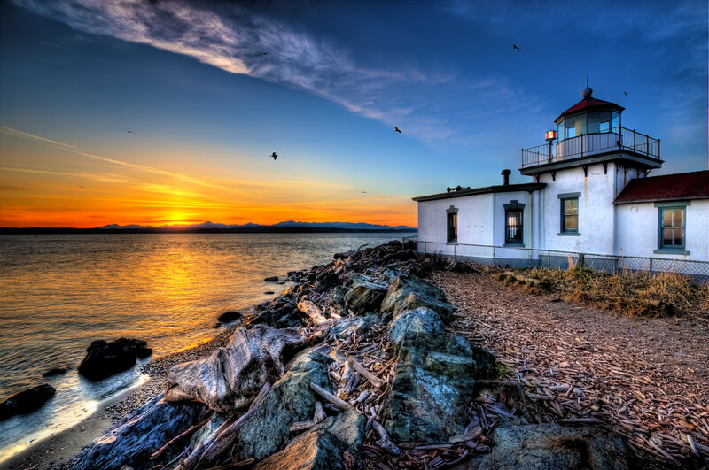 Lighthouse at sunset by the sea