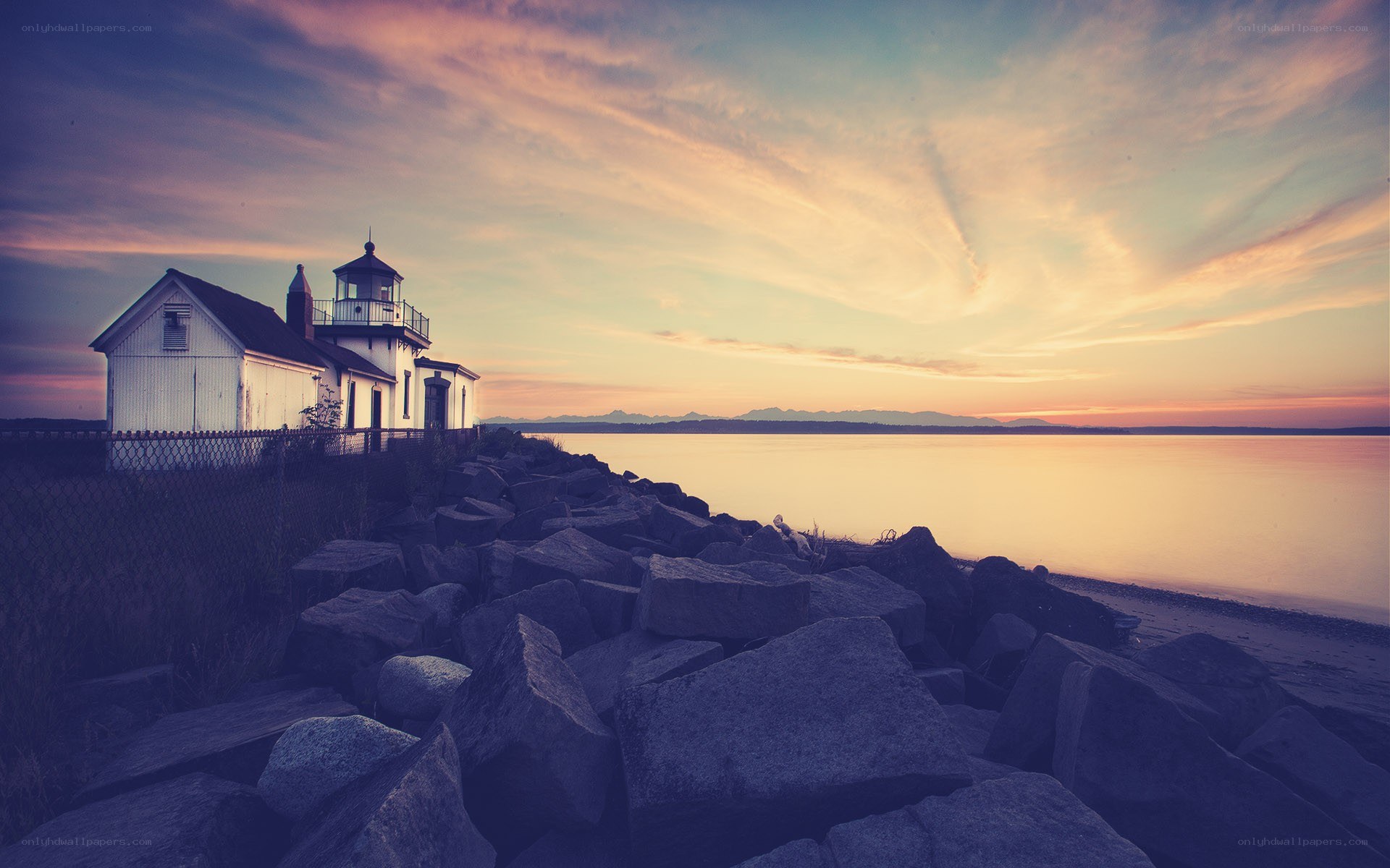Lighthouse at sunset by the water