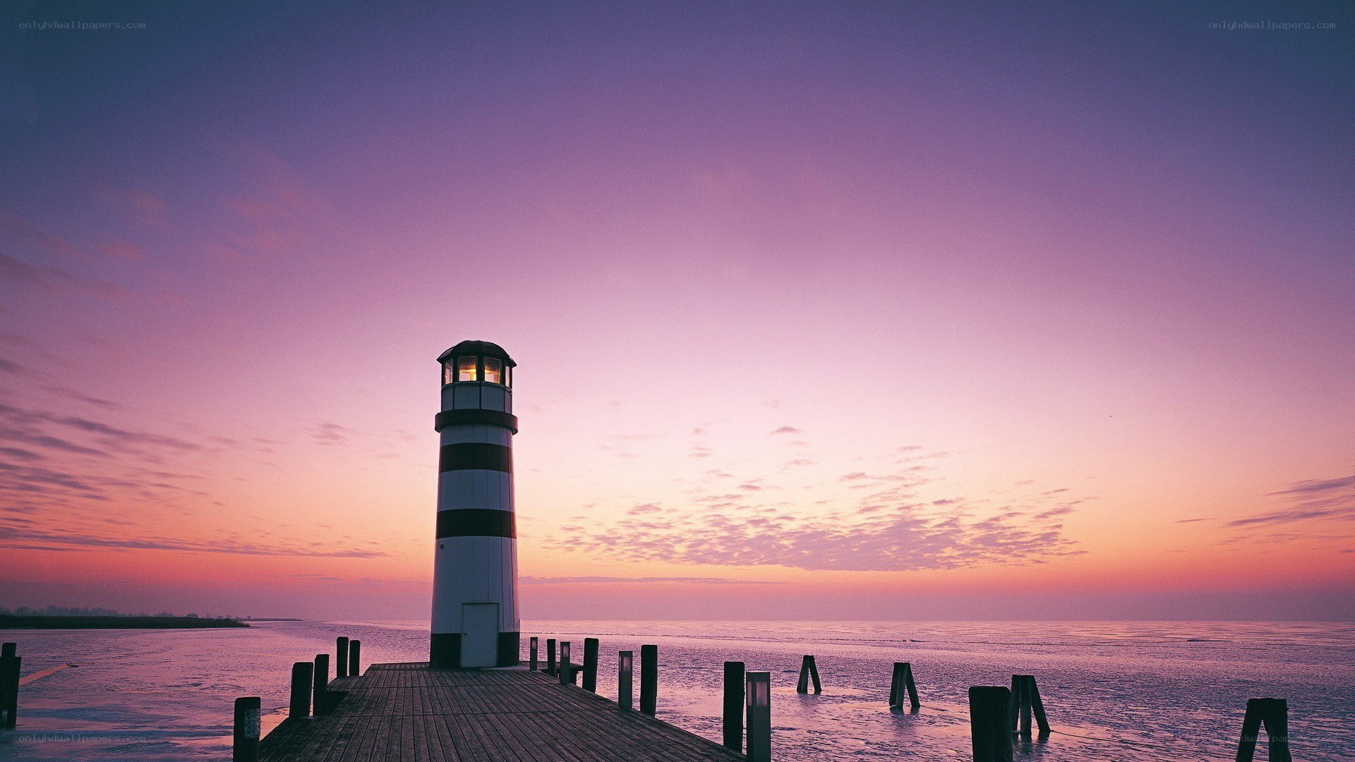 Lighthouse at sunset on a calm sea