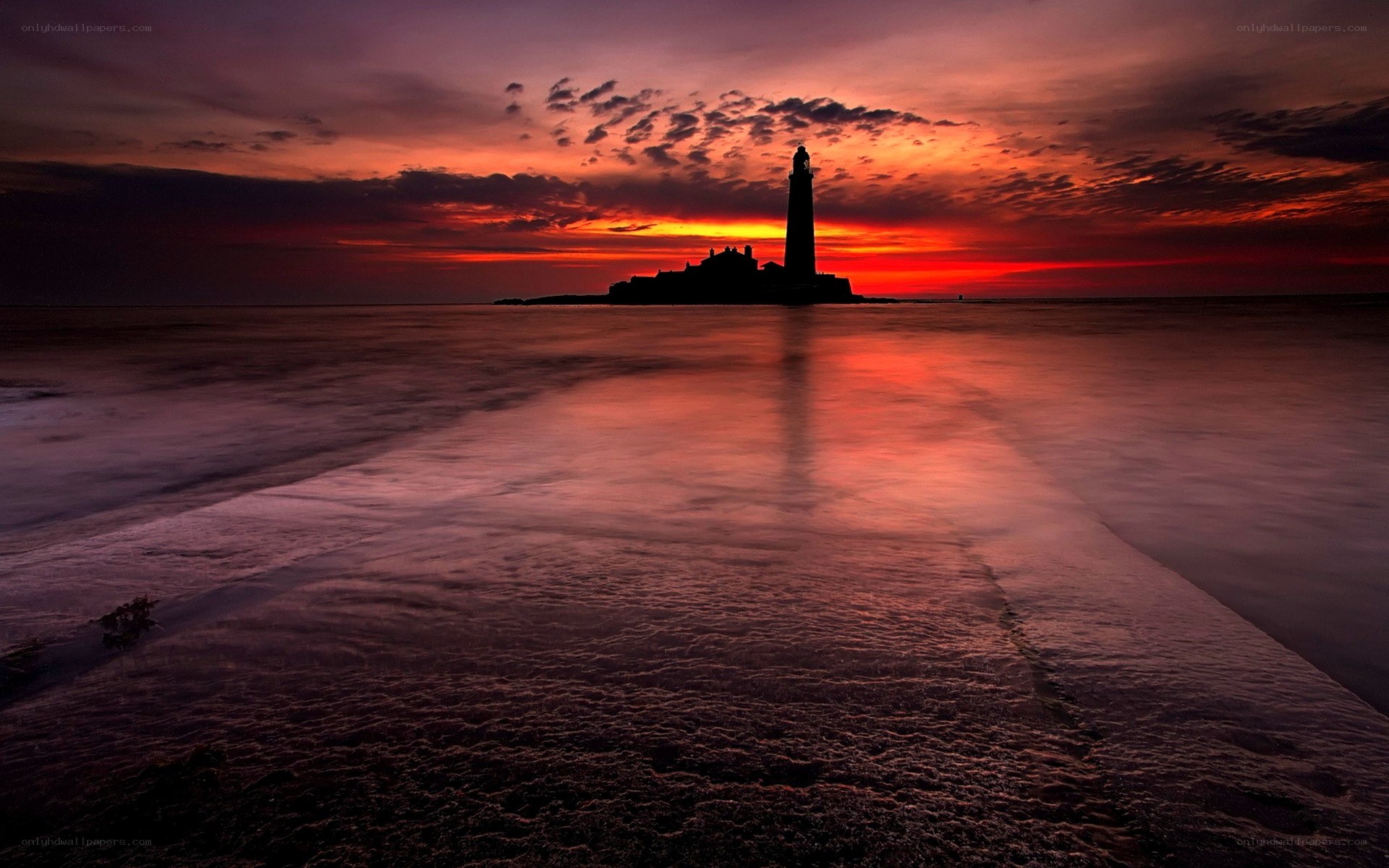 Lighthouse at sunset on a calm sea