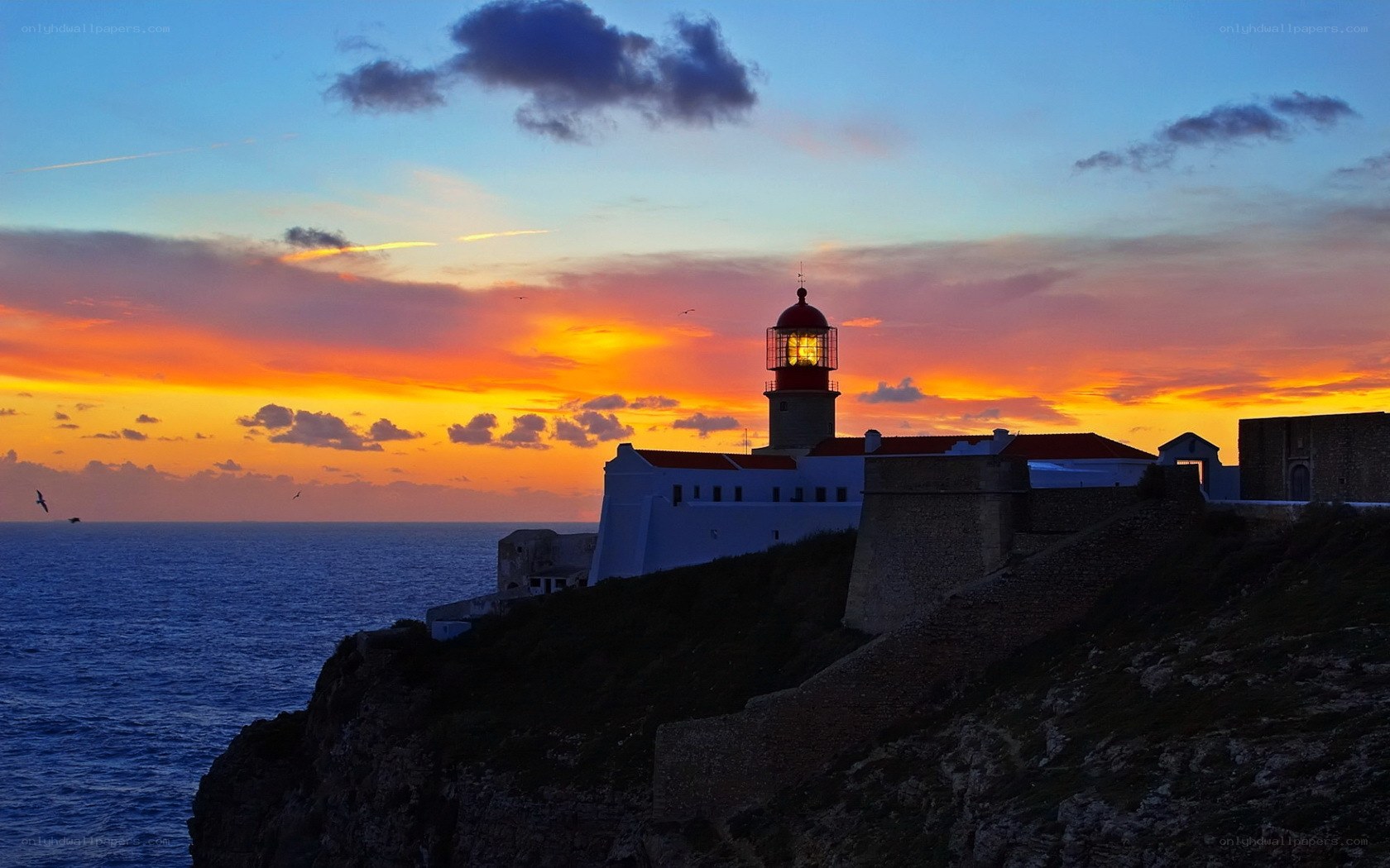 Lighthouse at sunset on a cliff