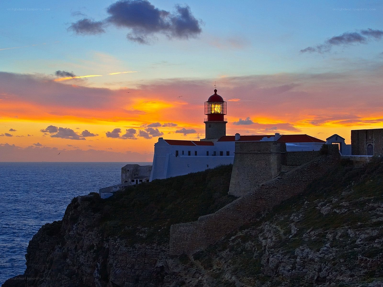 Lighthouse at sunset on a cliff