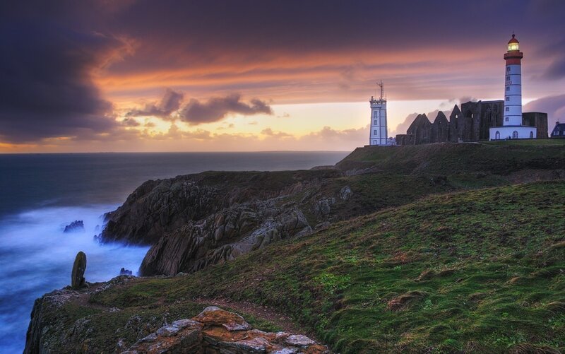 Lighthouse at sunset on a cliff