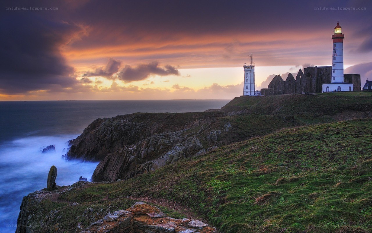 Lighthouse at sunset on a cliff