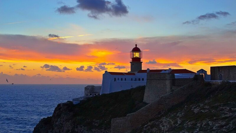 Lighthouse at sunset on a cliff