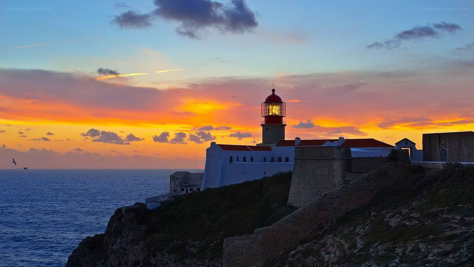 Lighthouse at sunset on a cliff
