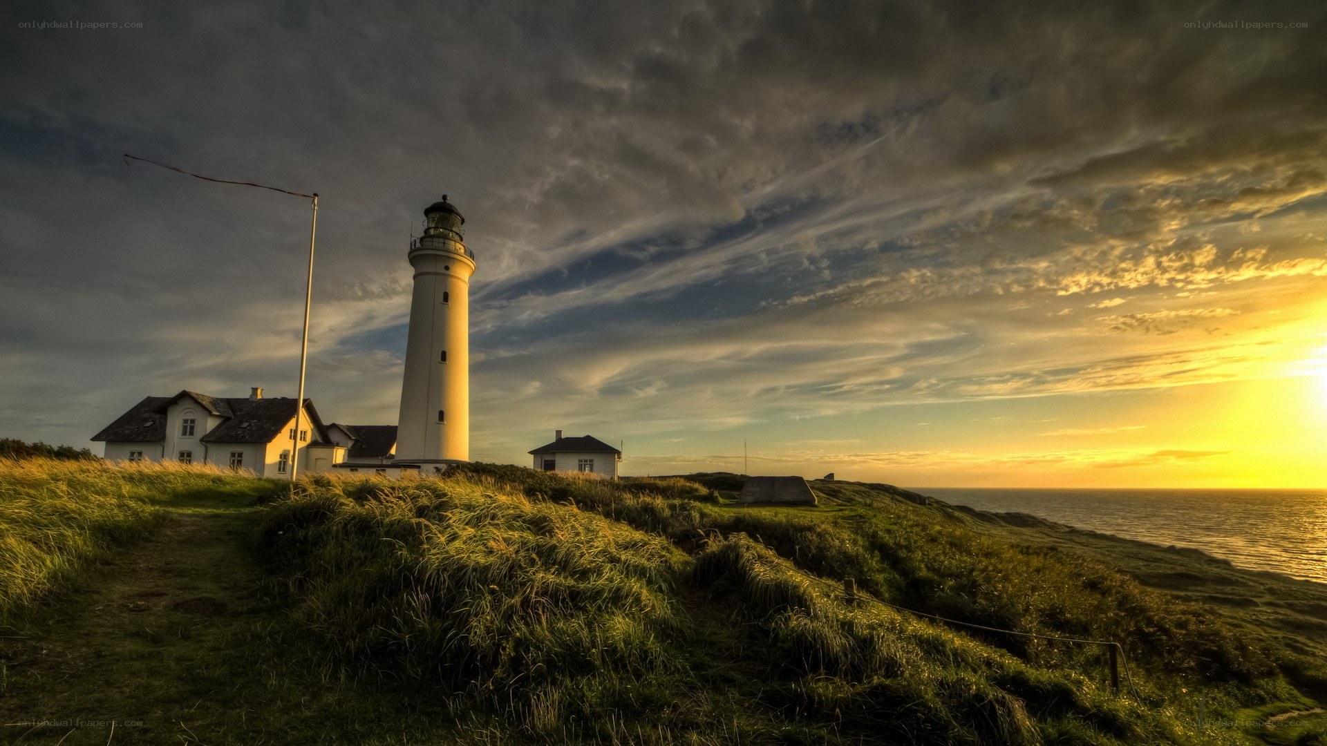 Lighthouse at sunset on a cliff