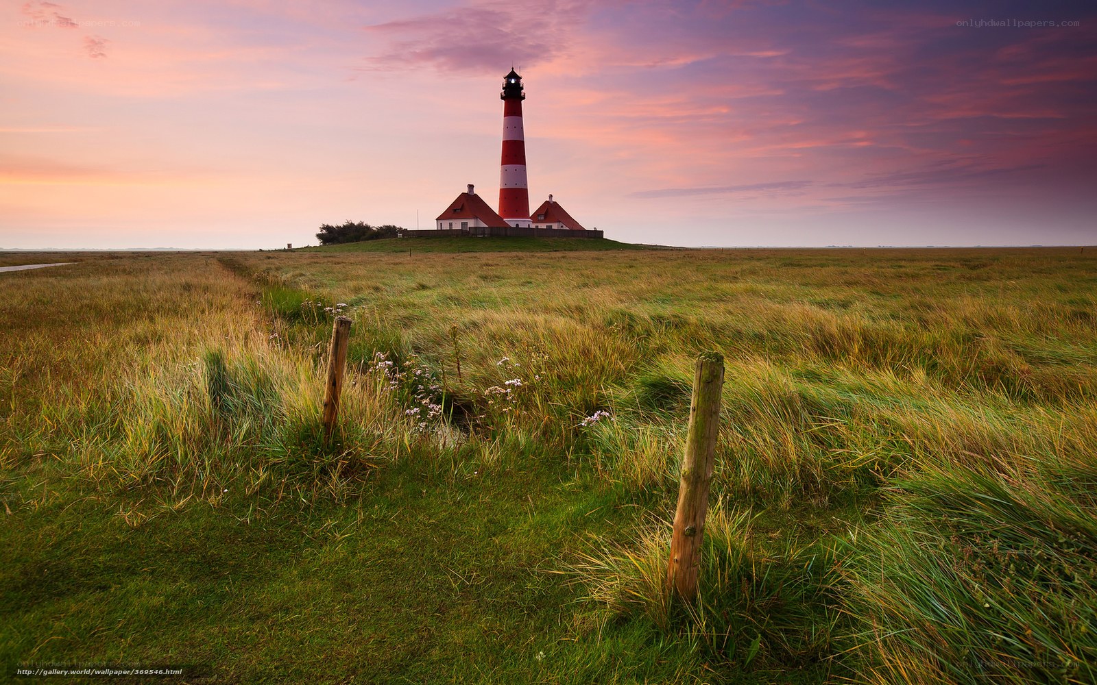 Lighthouse at sunset on a grassy field