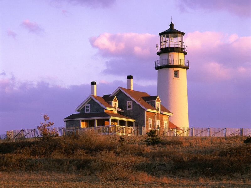 lighthouse at sunset on a hill