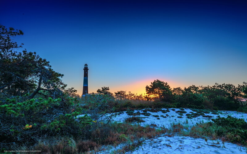 Lighthouse at sunset on a sandy dune