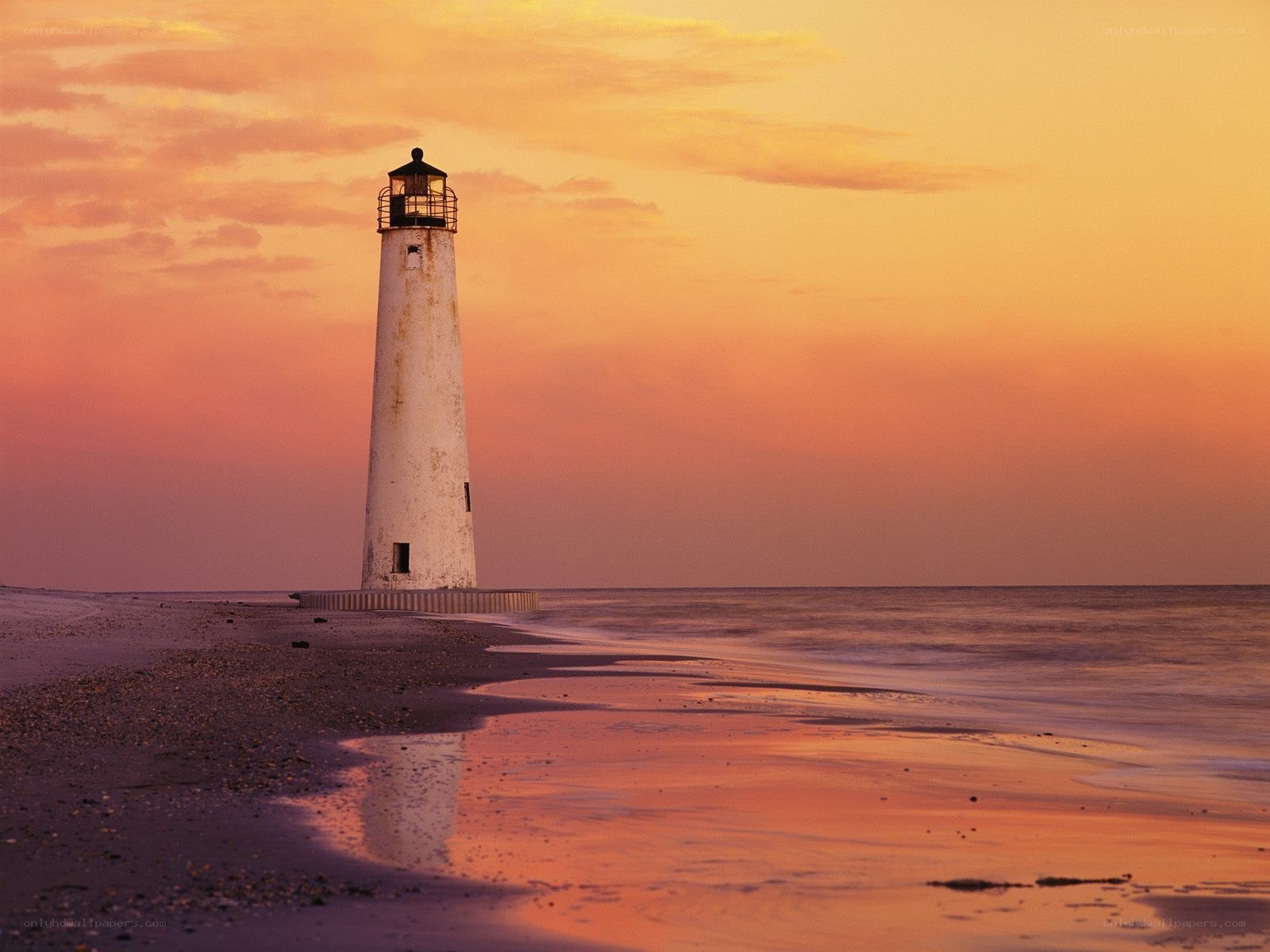 Lighthouse at sunset on beach