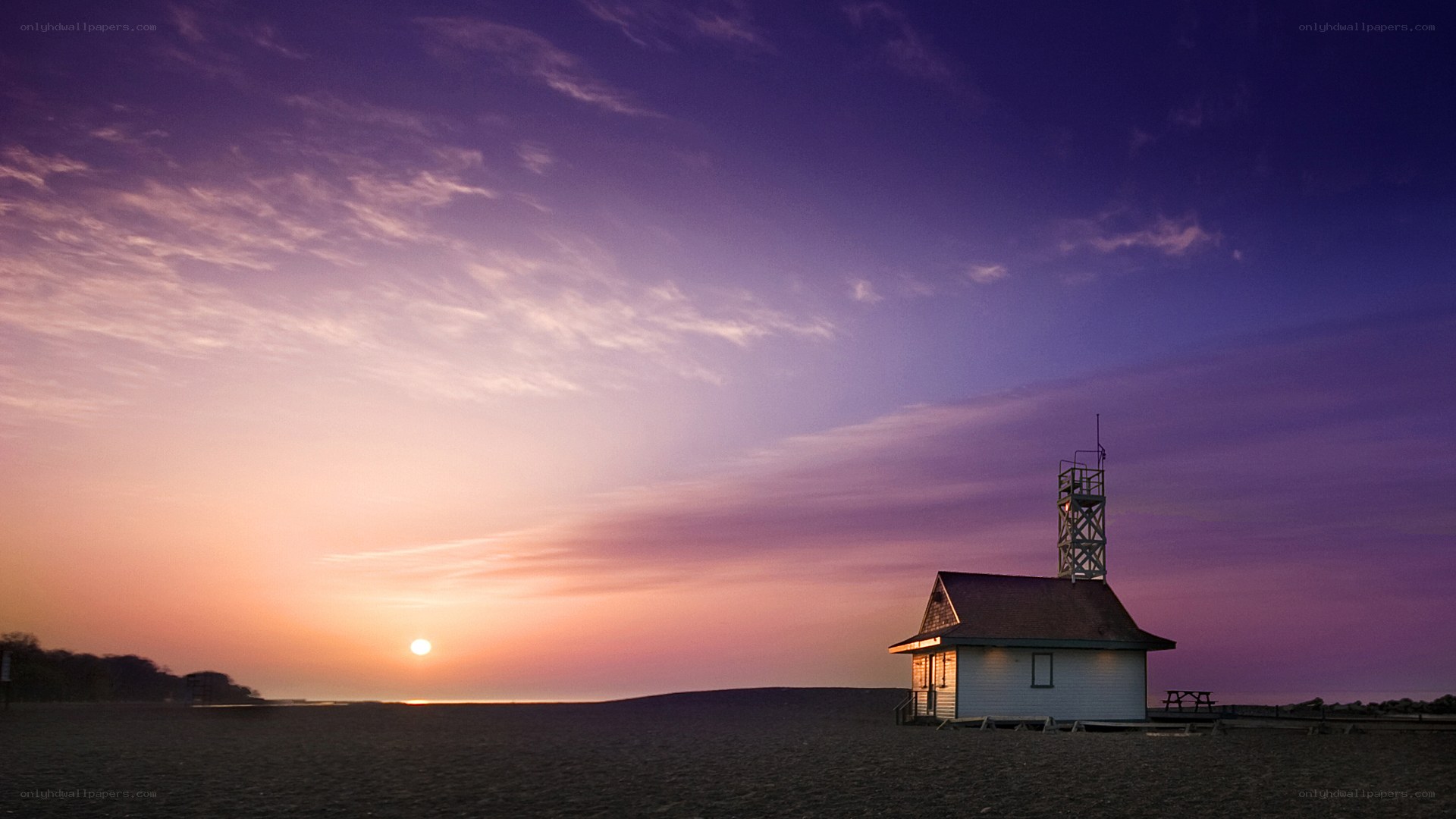 Lighthouse at sunset on beach