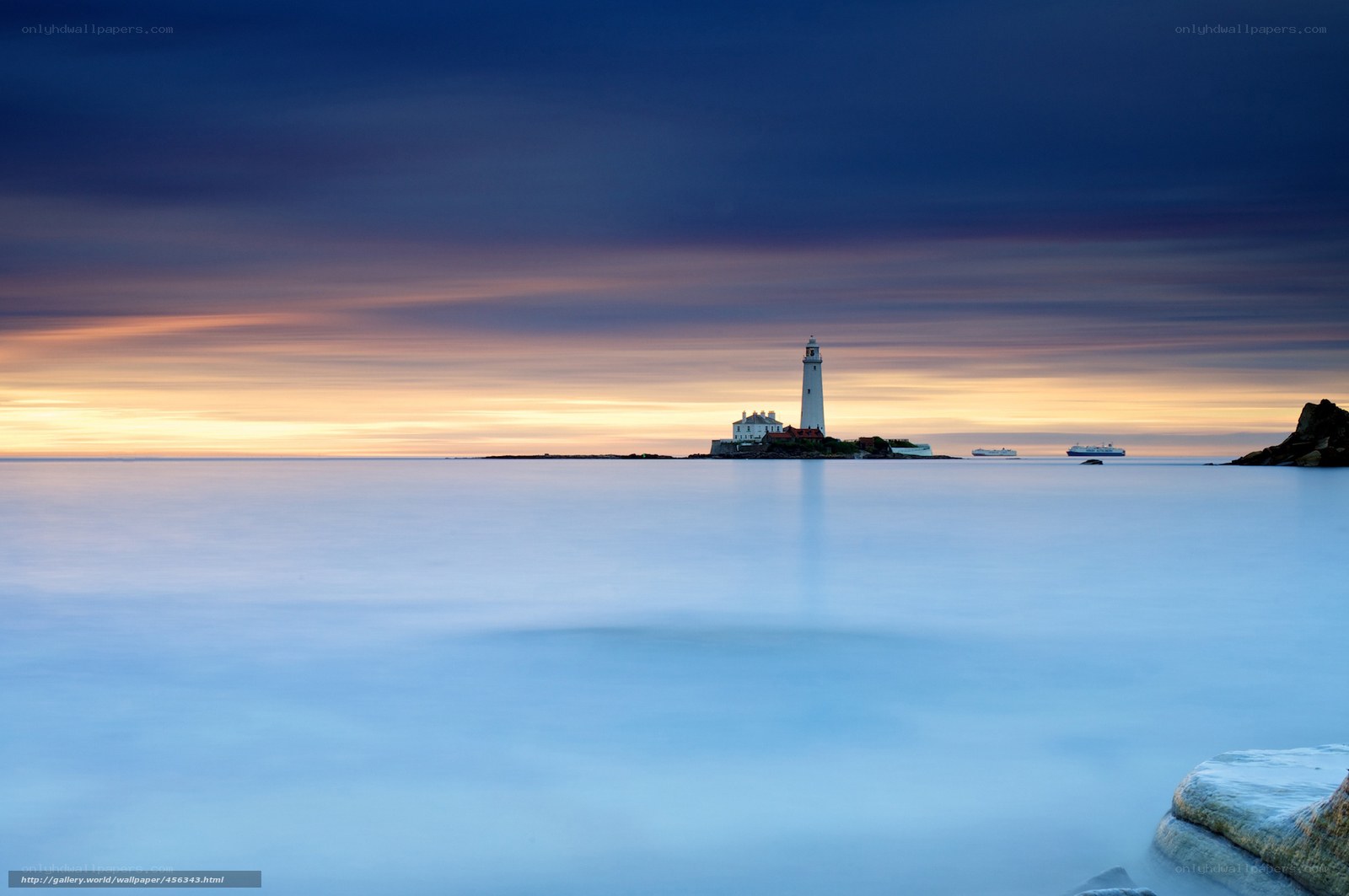 Lighthouse at sunset on calm sea