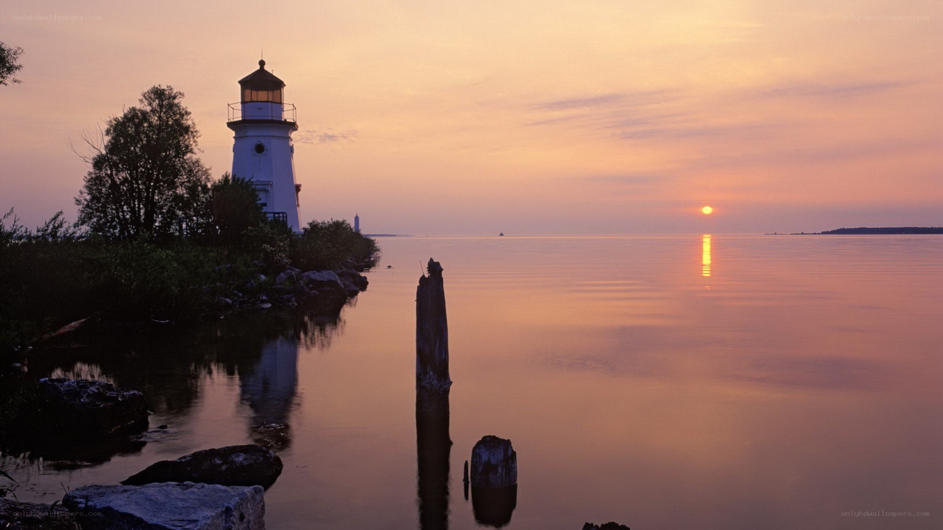 Lighthouse at sunset on calm water