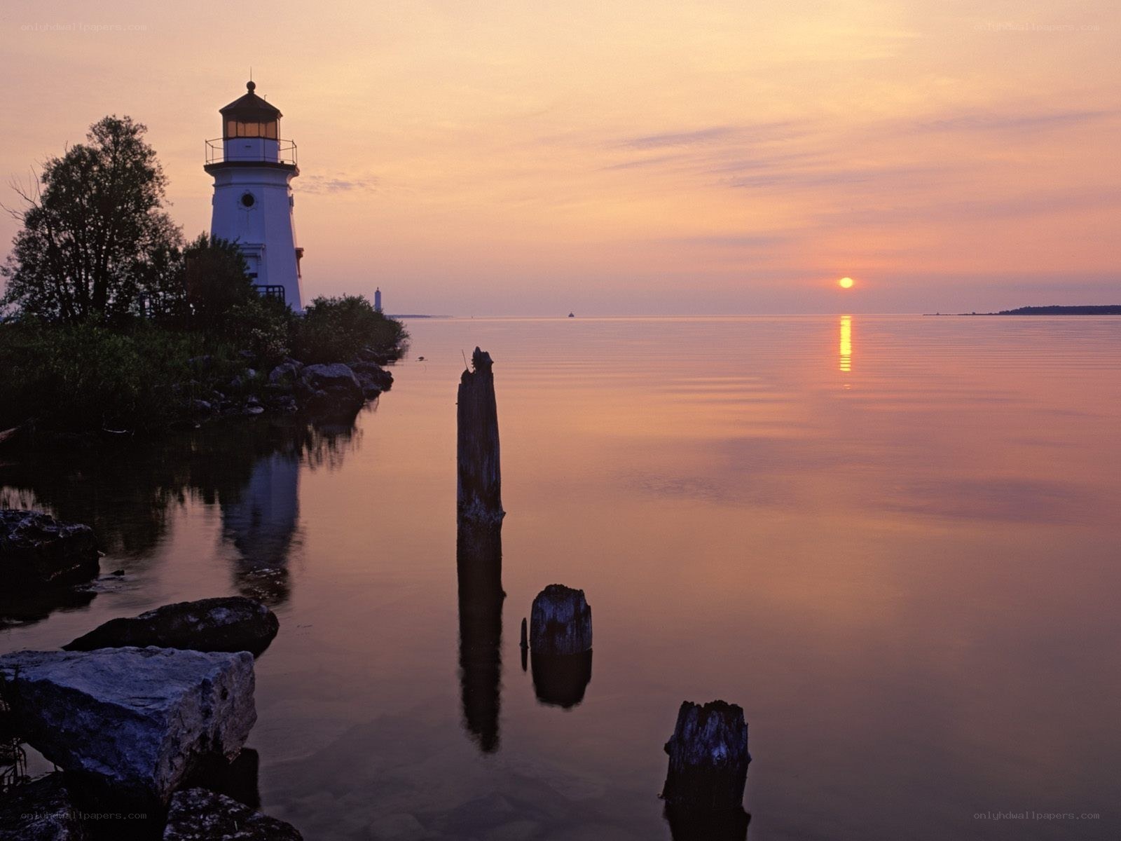 Lighthouse at sunset on calm water