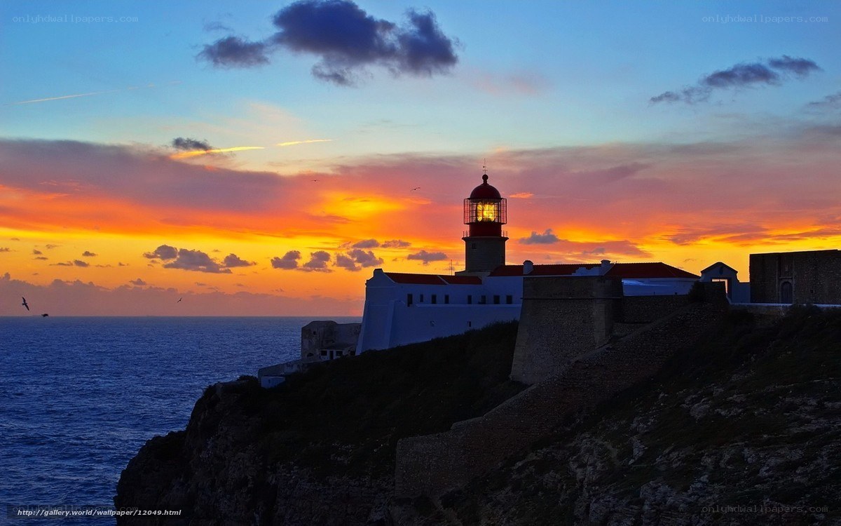 Lighthouse at sunset on cliff