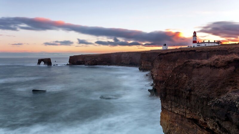 lighthouse at sunset on cliffs