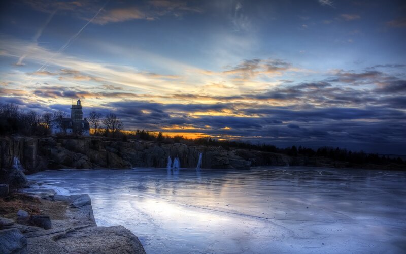 Lighthouse at sunset on frozen bay