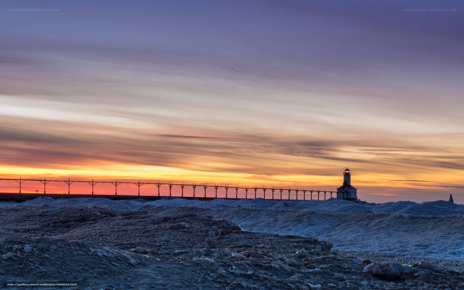Lighthouse at sunset on icy shore