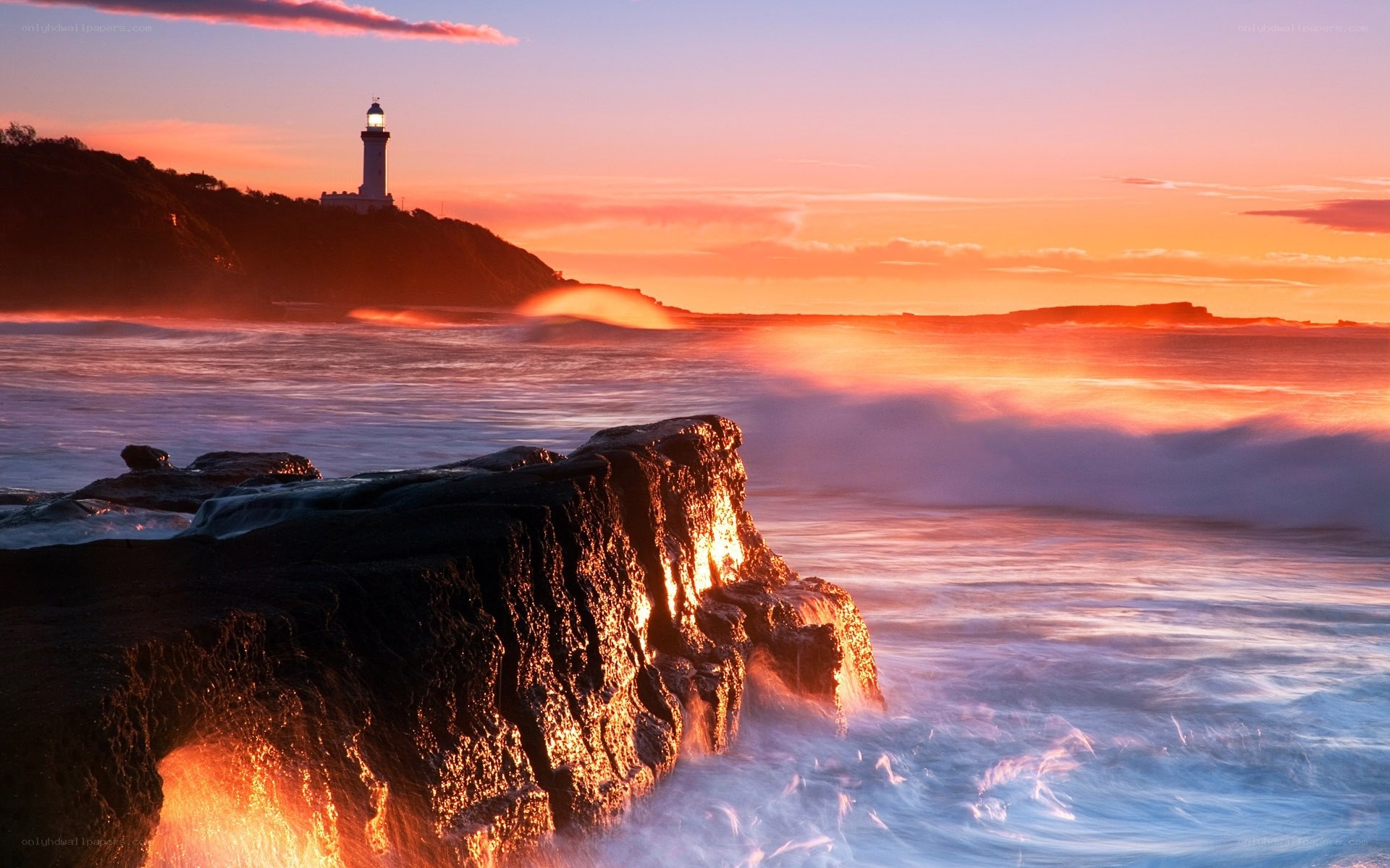 Lighthouse at sunset on rocky coast